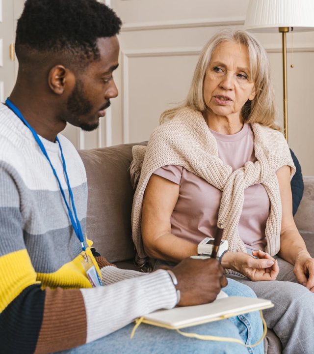 pexels-photo-7345463-7345463 A compassionate volunteer talking with an elderly woman during a home visit.
